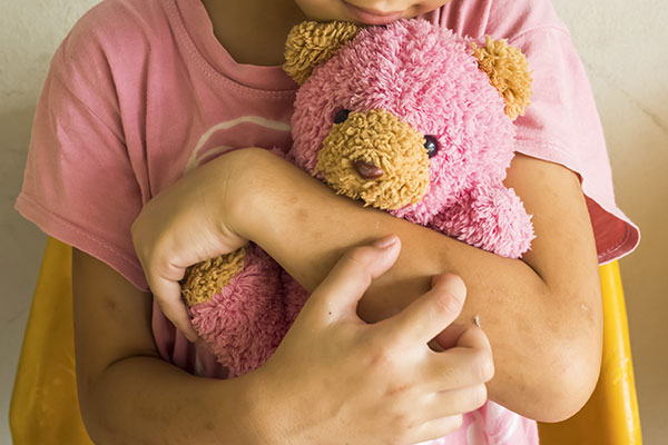 Child hugging a stuffed bear